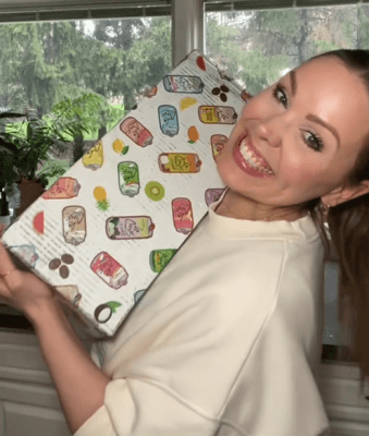 یک زن اینفلوئنسر با یک جعبه هدیه در دست